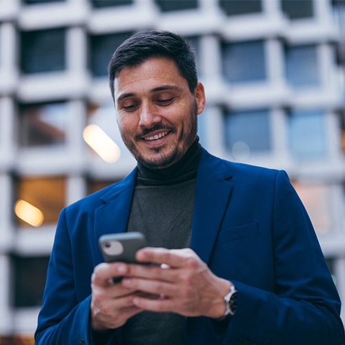 Um homem de terno azul olhando para o celular.